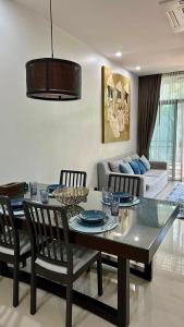a living room with a table and chairs and a couch at Cozy villa - perfect place to stay in Phuket in Ban Saiyuan (1)