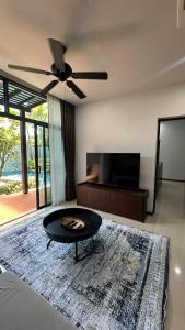 a living room with a ceiling fan and a table at Cozy villa - perfect place to stay in Phuket in Ban Saiyuan (1)