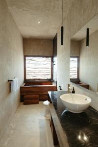 a bathroom with a sink and a tub at The Iggy Hotel Seseh Loft 6 in Cemagi