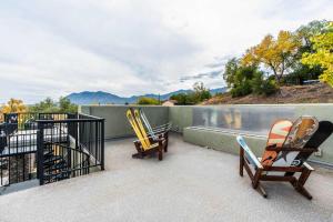 three chairs sitting on a balcony with a pool at 4BD Home w Rooftop Patio Fire Pit & Mountain Views in Colorado Springs