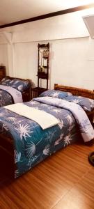 een slaapkamer met 2 bedden en blauwe en witte dekens bij Del Mar Residence 1 in Suizo