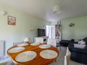 a living room with a wooden table and a couch at Maison Charmante 3* à Mimizan: Plages, Pistes Cyclables, Jardin, Wi-Fi, pour 8 Personnes - FR-1-50-137 in Mimizan