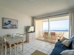 ein Wohnzimmer mit Tisch und Blick auf das Meer in der Unterkunft Appartement 6 pers., vue océan, Mimizan Plage, parking - FR-1-50-158 in Mimizan