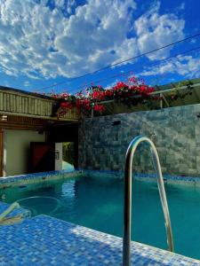 een zwembad met een hek en wat bloemen bij Casa BAMBU Club Simbal in Simbal