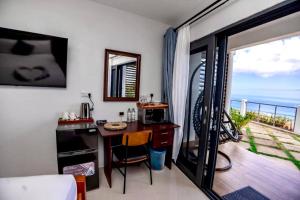 um quarto com uma escrivaninha com vista para o mar em Hammock Suite CoCo-Nut by ZenBreak em Charlotte