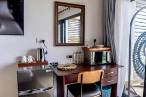 uma secretária com um espelho e uma cadeira num quarto em Hammock Suite CoCo-Nut by ZenBreak em Charlotte