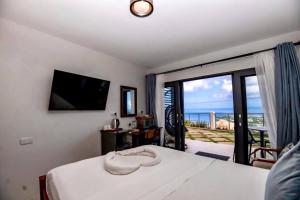 um quarto com uma cama com vista para o mar em Hammock Suite CoCo-Nut by ZenBreak em Charlotte