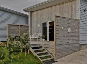 uma casa com uma rampa de madeira que leva a um alpendre em Stunning Sunsets & Views at Wonderful Wainui em Gisborne mais 14 fotografias