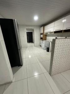 a large kitchen with white floors and white cabinets at cas de festa 1 in Recife