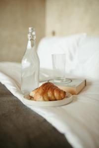 une assiette avec une pâtisserie et une bouteille sur un lit dans l'établissement The Iggy Hotel Seseh Loft 5, Sauna & Ice Bath, à Cemagi 42 autres photos