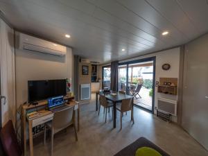 ein Wohnzimmer mit einem Tisch und einem Laptop darauf in der Unterkunft Chalet 3 chambres avec piscines chauffées et accès plage à 9km - FR-1-783-24 in Pomérols