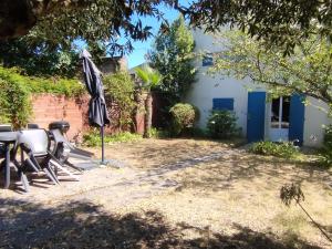 a patio with a table and an umbrella at Maison familiale 10 pers avec jardin et parking à Saint-Georges d'Oléron - FR-1-778-31 in Saint-Georges-dʼOléron
