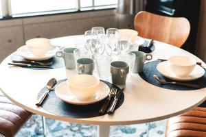 a white table with plates and glasses on it at Vinyl Stay - spacious local apartment in Osaka +23 photos