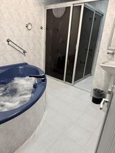 a bathroom with a blue tub and a sink at Casa Sierravista in Zacatlán