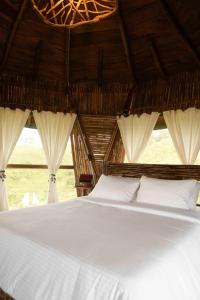 a bedroom with a bed with white sheets and curtains at HOTEl NUSS in San Roque +156 photos