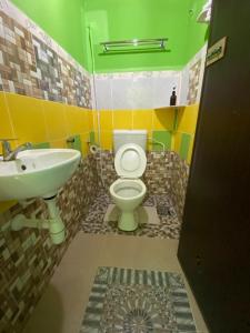 a bathroom with a toilet and a sink at Zackry Guesthouse in Pantai Cenang