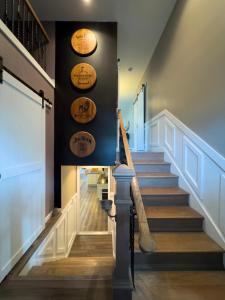 a staircase in a house with wooden floors and signs on the wall at Bourbon Blue - 8 min to Downtown Bardstown and Spacious! in Bardstown