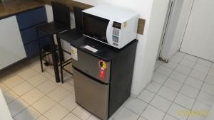 a microwave on top of a refrigerator in a kitchen at AP 219 Victory Flat em Tambaú in João Pessoa