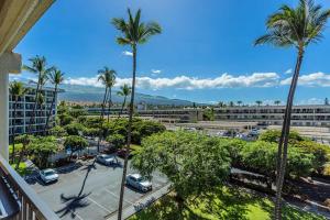 Blick auf einen Parkplatz mit Palmen und ein Gebäude in der Unterkunft Kihei Akahi Resort - Unit C618 in Wailea
