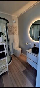 um banheiro com um vaso sanitário, uma pia e um espelho em Stunning Sunsets & Views at Wonderful Wainui em Gisborne