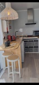 uma cozinha com um balcão com dois bancos e uma mesa em Stunning Sunsets & Views at Wonderful Wainui em Gisborne