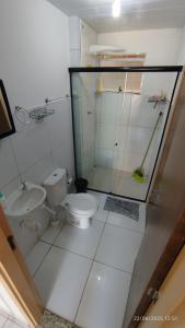 a white bathroom with a toilet and a shower at Casa aconchegante em Garanhuns in Garanhuns