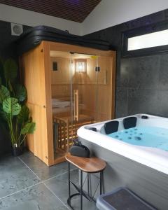 une grande salle de bain avec une baignoire et un tabouret dans l'établissement Cozy Loft with Sauna and Hot Tub, à Sarcelles