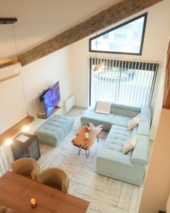 un salon avec un canapé bleu et une table dans l'établissement Cozy Loft with Sauna and Hot Tub, à Sarcelles