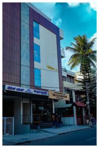 ein Gebäude auf einer Straße mit einer Palme in der Unterkunft Purple orchid in Bangalore