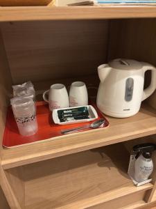 东京Hotel La'i ローレル Adult only的一个带咖啡壶和其他物品的架子