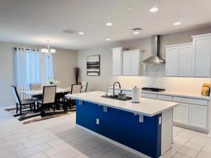 a kitchen with a blue island and a dining room at Friendly Host Near Loop 202 with Mountain views in Phoenix