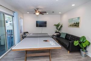 a living room with a table and a couch at Beach Retreat Complex w Pool - Sleeps 25 in Jacksonville Beach