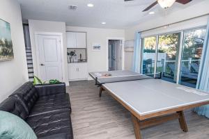 a living room with a ping pong table and a couch at Beach Retreat Complex w Pool - Sleeps 25 in Jacksonville Beach