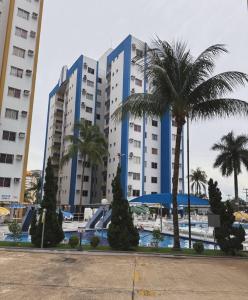 a large building with palm trees in front of it at Apartamento 2 Quartos Caldas Novas in Caldas Novas