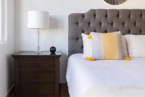 Private Villa in Cabo with Garden, Hot Tub & Medano Beach just 10 min away في كابو سان لوكاس: غرفة نوم مع سرير ومصباح على كومودينو +30 صورة