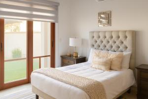 a bedroom with a large bed with a large window at Private Villa in Cabo with Garden, Hot Tub & Medano Beach just 10 min away in Cabo San Lucas