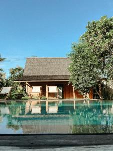 a house with a pool of water in front of it at The Iggy Hotel Seseh Studio 2, Sauna & Ice Bath in Cemagi
