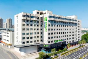 a white building with a sign on the side of it at Holiday Inn Express Shanghai Changyang Road by IHG in Shanghai