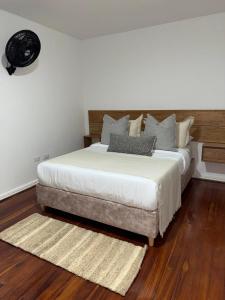 a bedroom with a large bed with a wooden headboard at Casa Alma Hospedaje in Mocoa +11 photos