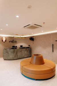 a lobby with a circular orange seat in the middle at Alite Enclaves Fully furnished apartments in Trichūr