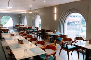 a restaurant with tables and chairs and windows at Alite Enclaves Fully furnished apartments in Trichūr