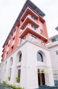 a building with an orange and white at Alite Enclaves Fully furnished apartments in Trichūr