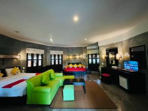 - une chambre avec un grand lit et un canapé vert dans l'établissement The Hideaway Pariya Haad Yuan Ko Pha-ngan, à Haad Yuan