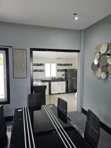 a dining room with a table and chairs and a kitchen at Beautiful New 3 Bed 3 Bathroom Villa 400m to Bang Tao Beach Sleeps 9 in Ban Thalat Choeng Thale
