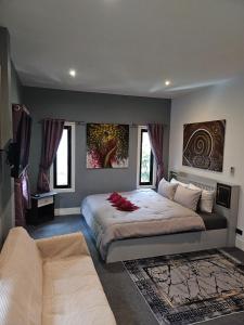 a bedroom with a large bed and a couch at Beautiful New 3 Bed 3 Bathroom Villa 400m to Bang Tao Beach Sleeps 9 in Ban Thalat Choeng Thale