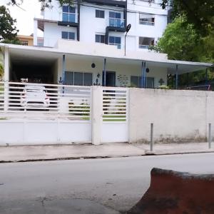 ボカ・チカにあるHabitacion cerca de la Playaの白い建物前の白い柵