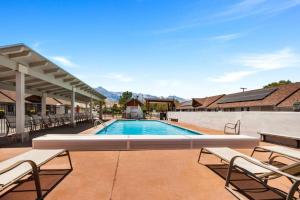 a swimming pool with chaise lounge chairs around it at Best Western Frontier Motel in Lone Pine