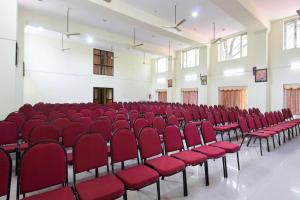 an empty room with red chairs in a hall at Sree Gokulam Sabari in Guruvāyūr