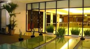 a lobby with potted plants in a building at Travello Hotel Manado in Manado