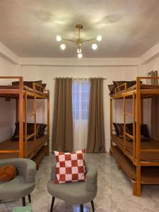 a room with bunk beds and a couch and a chair at Isle Be Back Catanduanes Staycation - Cavinitan in Virac